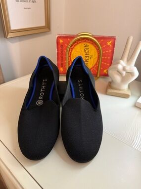 Rothy's Black Slip-On Flats with Blue Trim